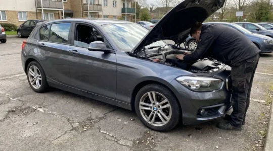 Une personne inspectant le compartiment moteur d